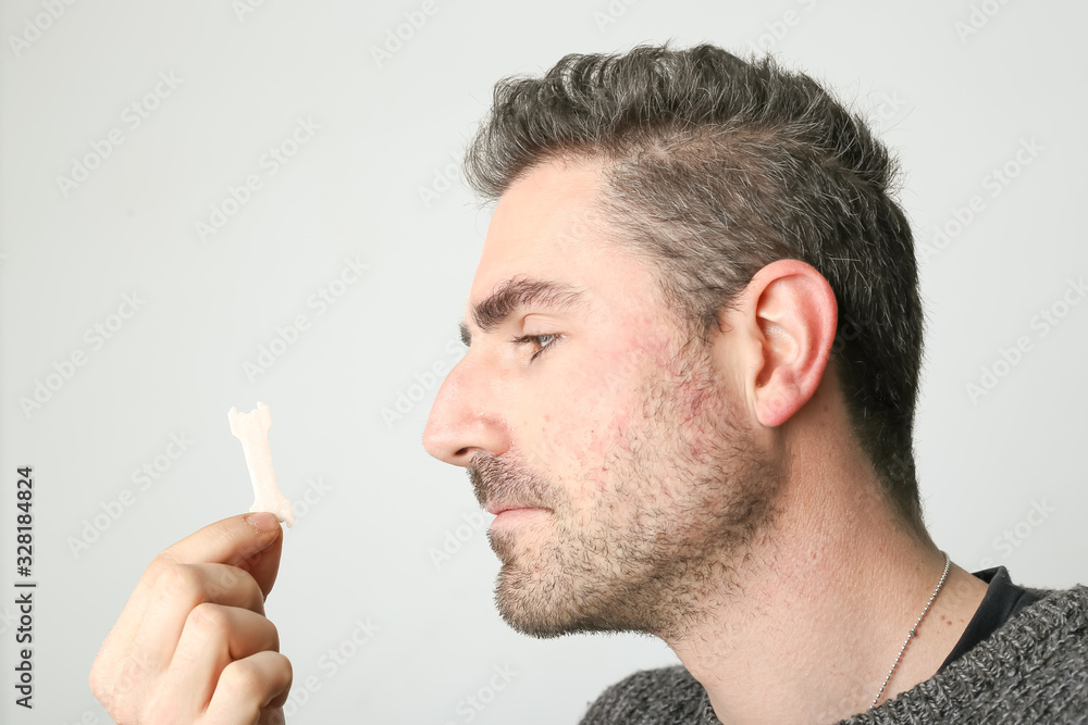 Foto de Man observing a new nasal strip, external nasal dilator strip