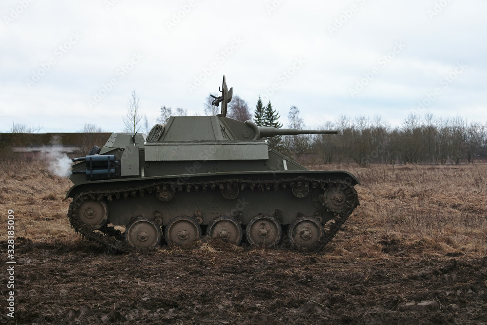 Ggreen tank of the second world war rides on a field with dry grass on Festival of living history Ggreen tank of the second world war rides on a field with dry grass on Festival of living history