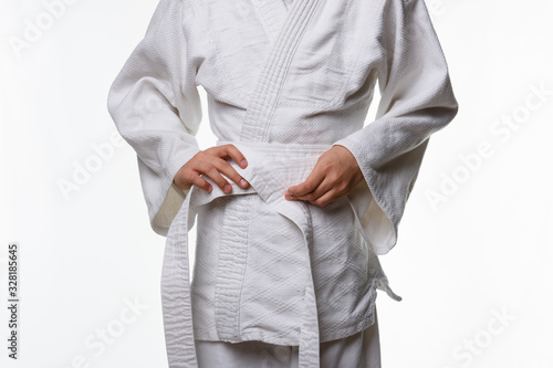 Stages of correct tying of the belt by a teenager on a sports kimono, step five photo