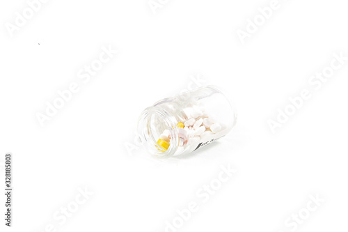 glass medicine container with pills on a white isolated background