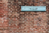 Blank sign on a brick wall of a train station