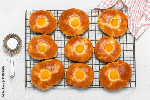 Fresh baked easter bread rolls with apricot on cake cooling rack for breakfast. Top view. Homemade sweet food concept.