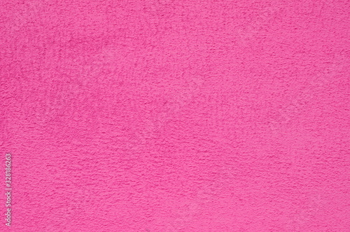 Background of a pink stucco coated and painted exterior, rough cast of cement and concrete wall texture, decorative coating