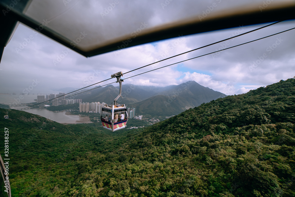 Cableway passing in front of Hong Kong residential buildings and jungle
