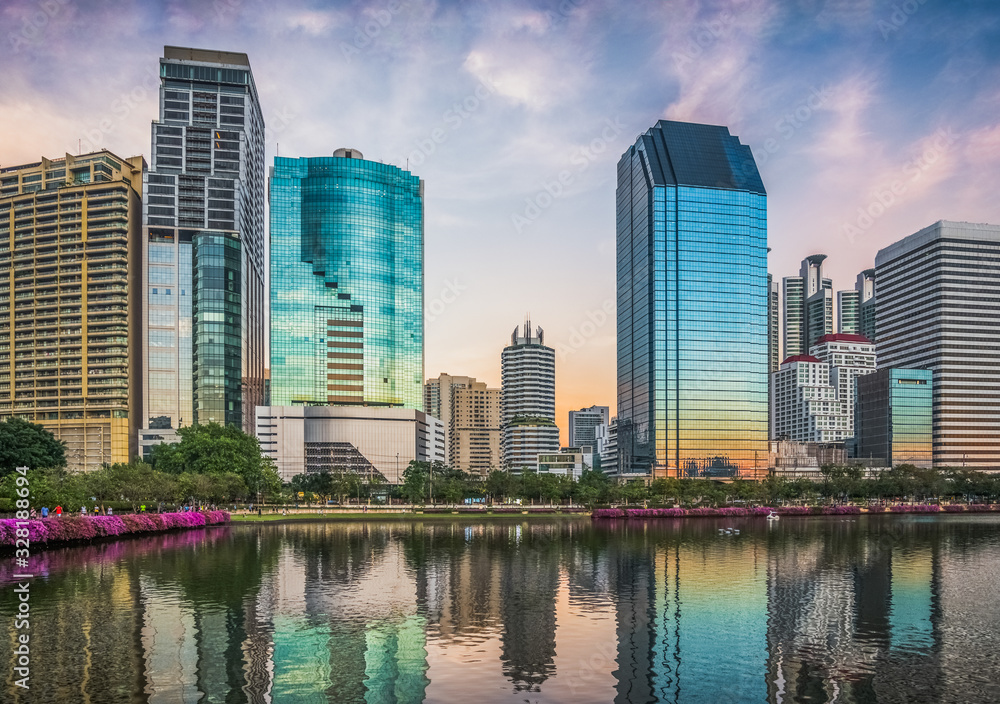 Fototapeta premium Wieżowce odbite w jeziorze o zmierzchu. Benjakiti Park w Bangkoku w Tajlandii