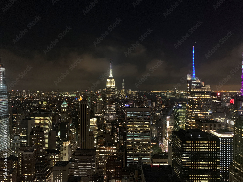 Aerial view of Manhattan, one of the most touristic places in the city. New york city, manhattan skyline at dusk or nighttime with dark cloudy sky and lights. The Empire State Building, Chrysler build