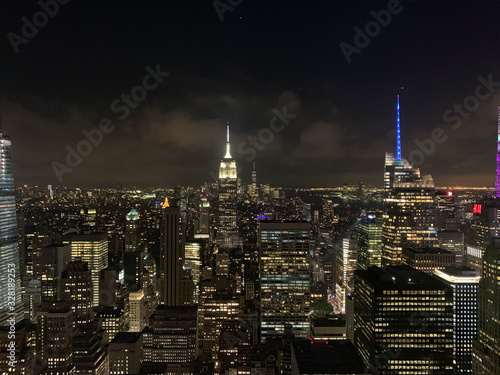 Aerial view of Manhattan  one of the most touristic places in the city. New york city  manhattan skyline at dusk or nighttime with dark cloudy sky and lights. The Empire State Building  Chrysler build