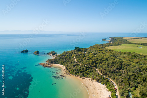 Aerial view of ocean coastline with shallow azure water and coastal vegetation