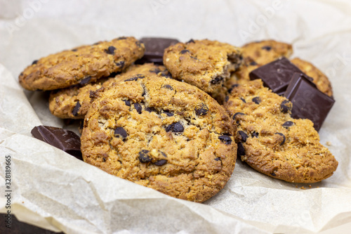 Freshly baked American chocolate chip cookies on rustic black metal table background