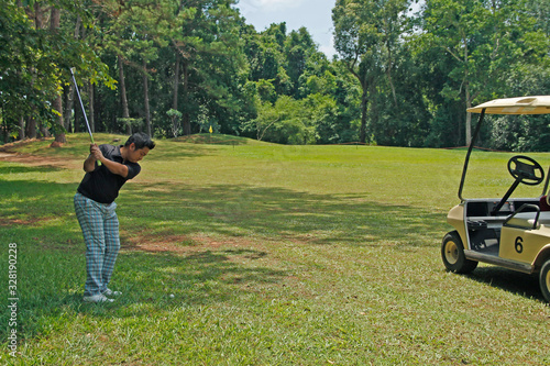 Blurred golfer playing golf in beautiful golf course in the evening golf course with sunshine in thailand