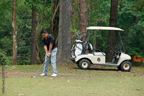 Blurred golfer playing golf in beautiful golf course in the evening golf course with sunshine in thailand