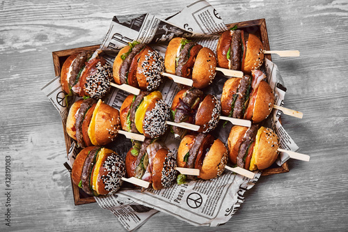 Fotografi Set of Tasty cheeseburger in a wooden box on a light background