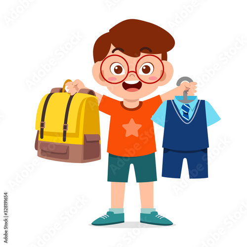 happy cute little kid boy preparing uniform for school