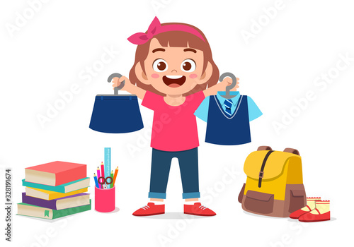 happy cute little kid girl preparing uniform for school