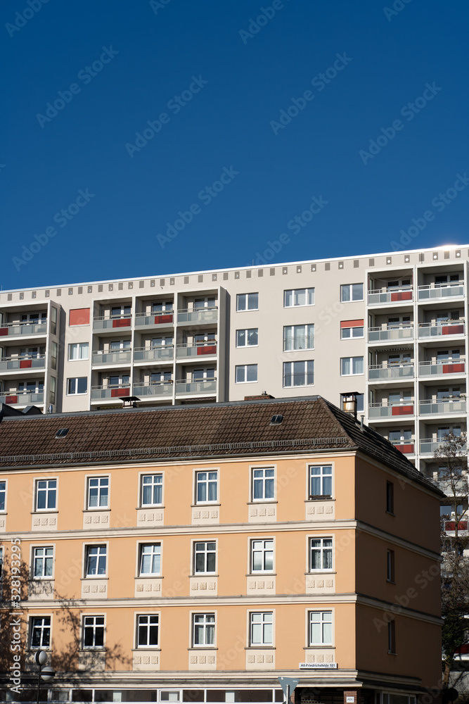 contrasting facades in the city of berlin, colourful old buildings and new skyscrapers with blue sky in the background, modernised buildings with fresh colours on the facades
