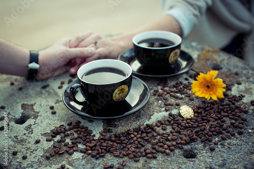 Couple cup of coffee with hands and beans