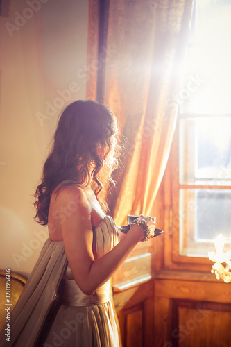 young woman sitting on the window sill
