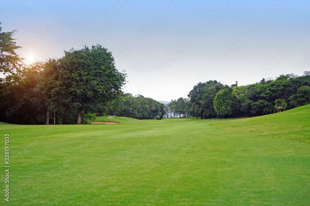 The evening golf course has sunlight shining down at golf course in Thailand