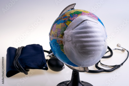 Protective surgical face mask on a terrestrial globe model. Coronavirus Concept. Surgical mask with rubber ear straps. Corona virus   nCoV  covid 19.  Coronavirus outbreak.