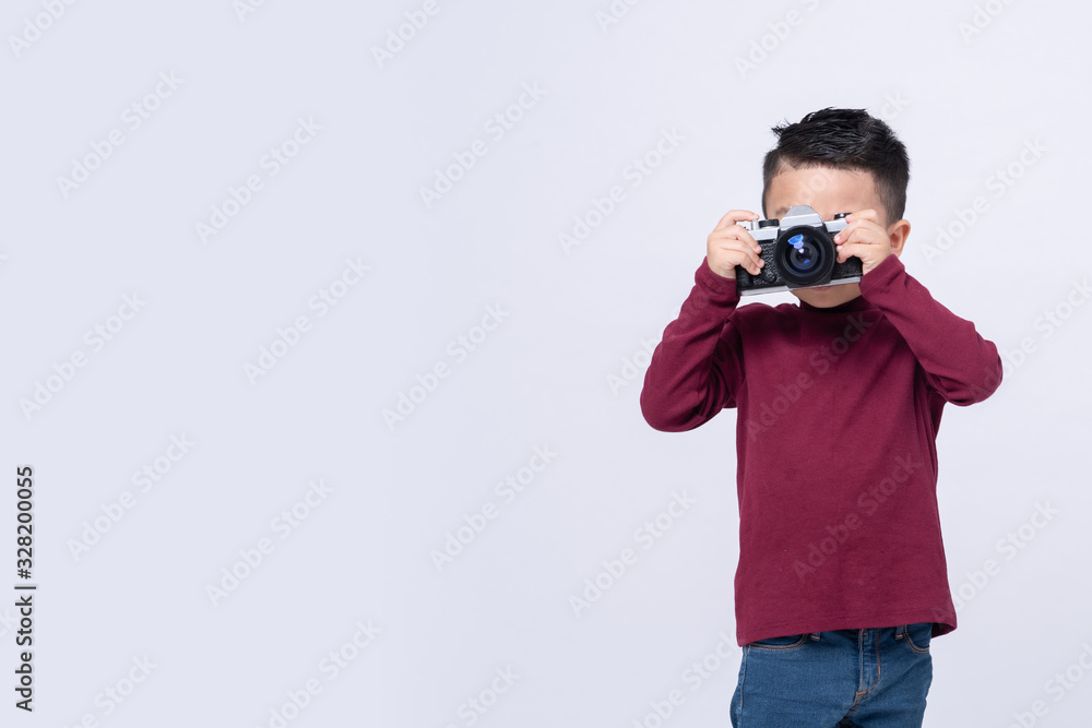 Portrait of little boy wearing red sweater standing isolated on grey background taking photo with film camera. Portrait of little boy wearing red sweater standing isolated on grey background taking photo with film camera.
