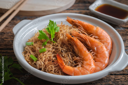 Foto Baked prawn with vermicelli in white pot and soy sauce