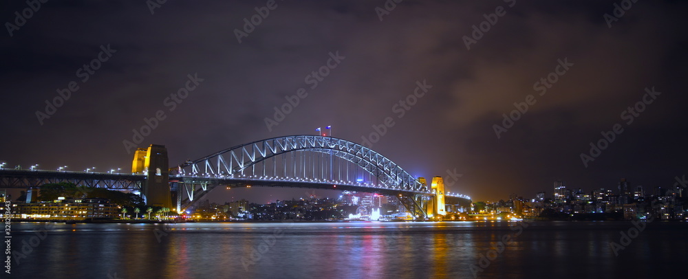 Obraz premium Sydney Harbour Bridge illuminating the harbour and circular quay with vibrant colourful lights at midnight in NSW Australia