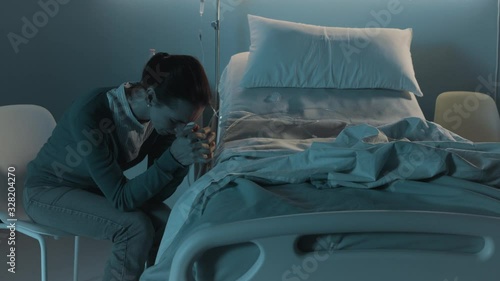 Sad woman crying next to an empty hospital bed