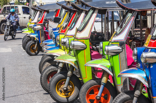 Tuk-tuks lined up in a row,