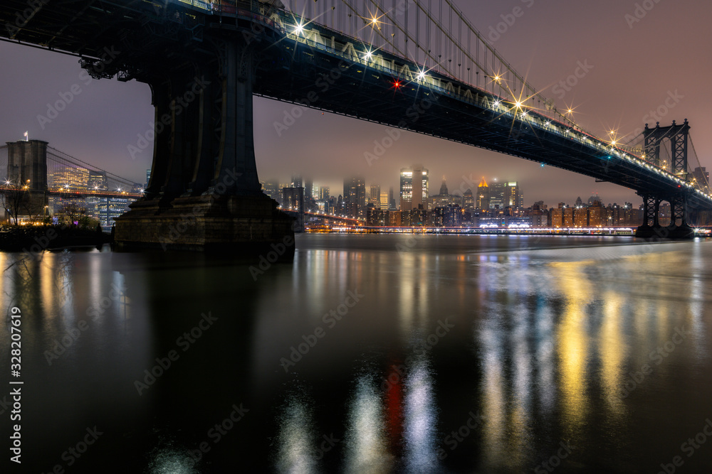 East River view on a foggy night with Manhattan Bridge,Brooklyn bridge, Financial District long exposur photo