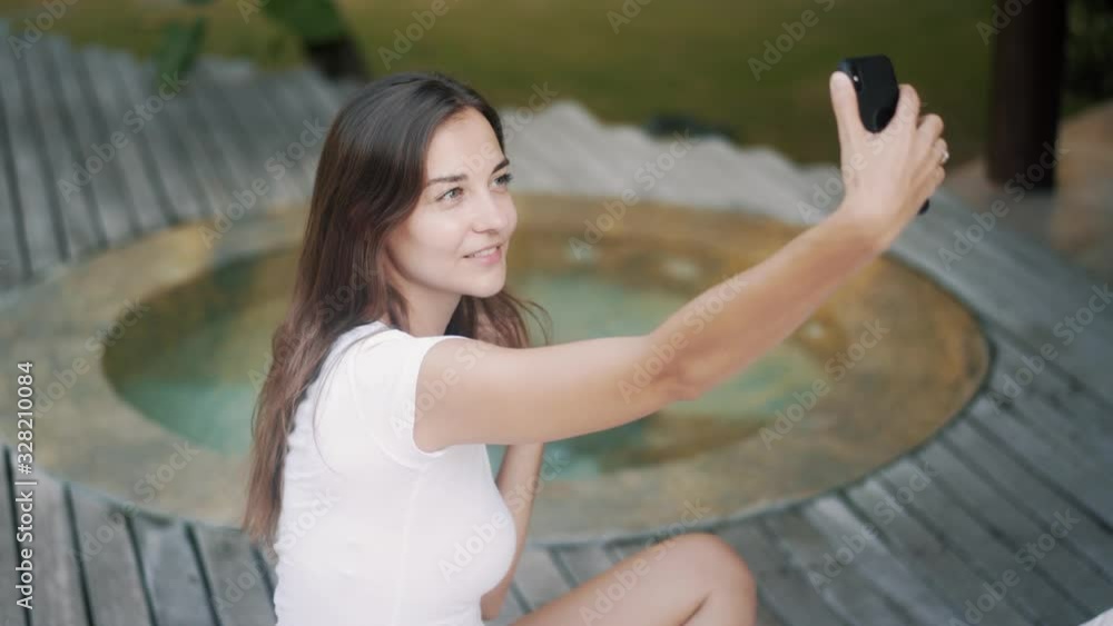 elegant lady makes selfie near pool at tropical resort elegant lady makes selfie near pool at tropical resort