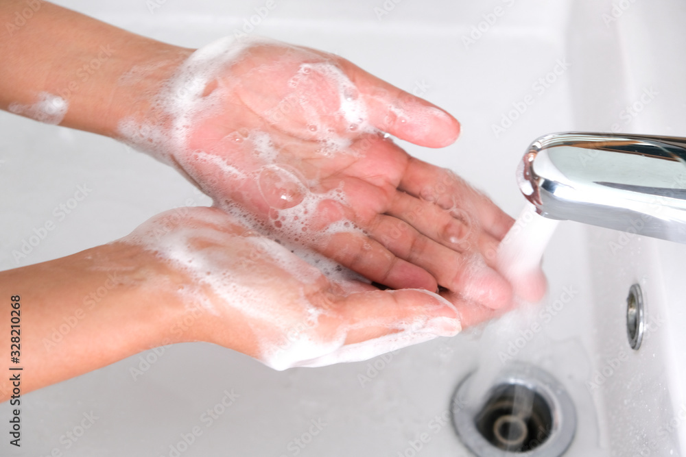 Fototapeta premium hand of beauty woman wash your hands at the wash basin with foam, cleanse the skin and have water flowing through the hands. Health and beauty concepts