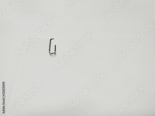 Close up of paper clip holding a blank paper sheet on white background.