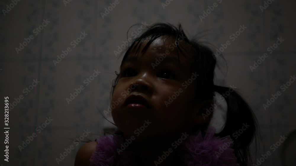 Cute little girl feel scared while sitting on the toilet bowl with broken flickering fluorescent light in the bathroom at public park. Cute little girl feel scared while sitting on the toilet bowl with broken flickering fluorescent light in the bathroom at public park.