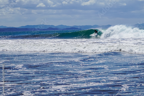 Beautiful aerial view of surfers surfing in Naranjo Beach 