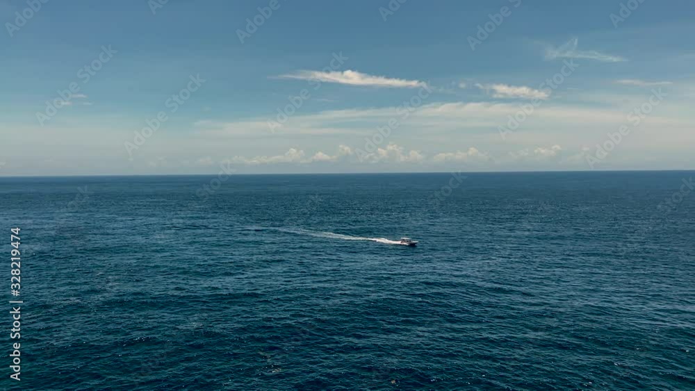 Distant view of motorboat sailing alone in the sea slomo Distant view of motorboat sailing alone in the sea slomo