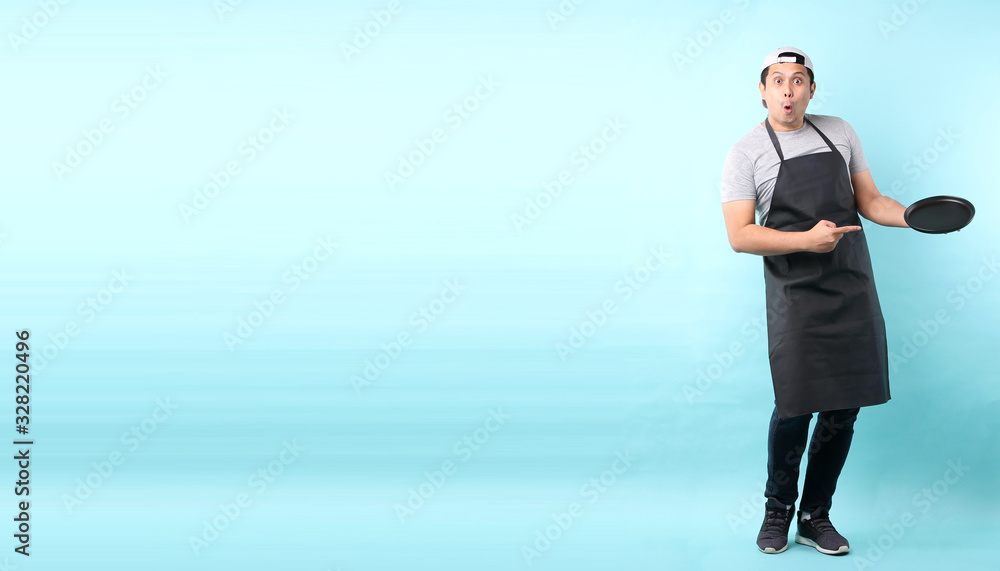 Dining concept. Asian man waiter holding an empty plate.isolated on blue background in studio With copy space. Dining concept. Asian man waiter holding an empty plate.isolated on blue background in studio With copy space.