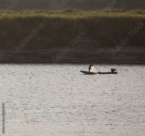 silhouette fisherman boat on mekong river