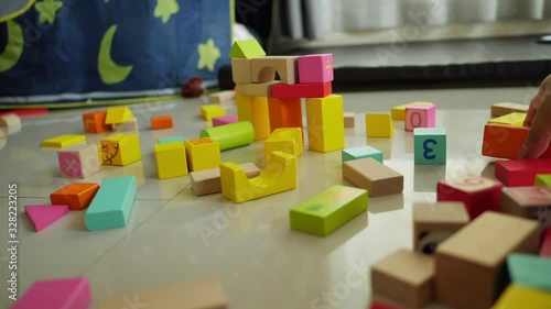 slow motion, happy cute boy playing colorful wooden block toy building in home living room