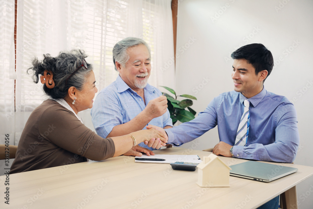 Obraz premium Asian couple grandparent are happy with insurance agency manager after deal the agreement successful, financial planner presenting and Closing the sale of real estate