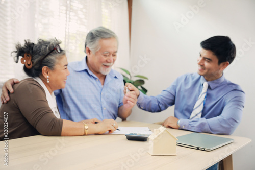 Asian couple grandparent are happy with insurance agency manager after deal the agreement successful, financial planner presenting and Closing the sale of real estate
