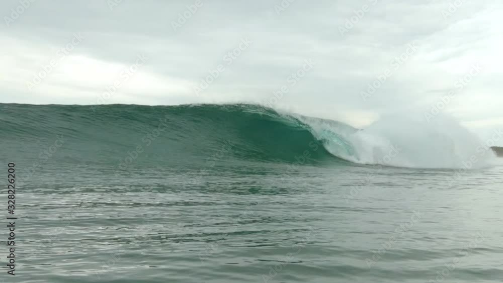 A clean wave barreling filmed from in the water with the offshore spray blowing off the wave. A clean wave barreling filmed from in the water with the offshore spray blowing off the wave.