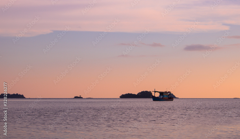 Fishing boat on the sea at summer sunset time.