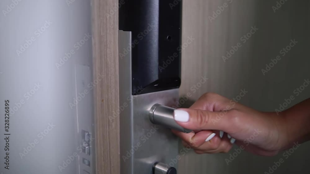 hand of a young woman with a beautiful manicure takes a door handle and open door lady welcomes honored guests at the door hand of a young woman with a beautiful manicure takes a door handle and open door lady welcomes honored guests at the door