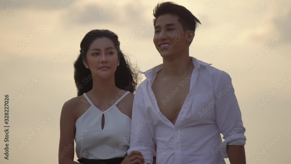 lovely young couple walking by the sea holding hands happy lovers spend time together outdoors honeymoon in exotic place lovely young couple walking by the sea holding hands happy lovers spend time together outdoors honeymoon in exotic place