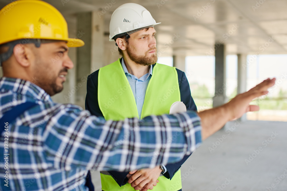 Two engineers discuss work related questions together. Two engineers discuss work related questions together.