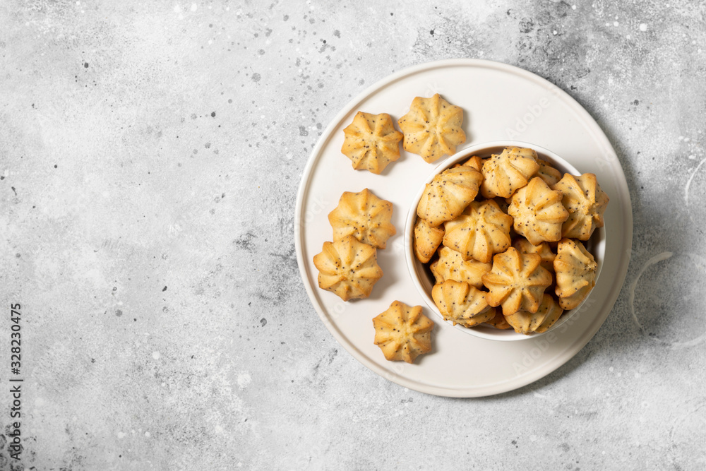 Lemon cookies with poppy seeds in a white ceramic bowl on the gray kitchen table. Shortbread. Space for text Lemon cookies with poppy seeds in a white ceramic bowl on the gray kitchen table. Shortbread. Space for text