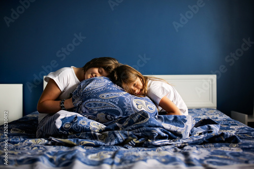Tired children fell asleep on the bed in bedroom