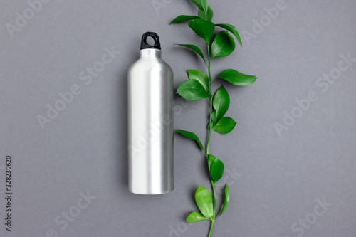 Layout of bottle and ruscus branch. Minimalistic zero waste concept.