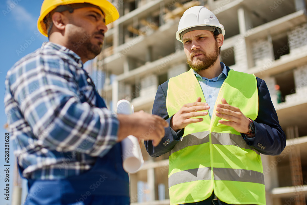 Two engineers discuss work related questions together. Two engineers discuss work related questions together.