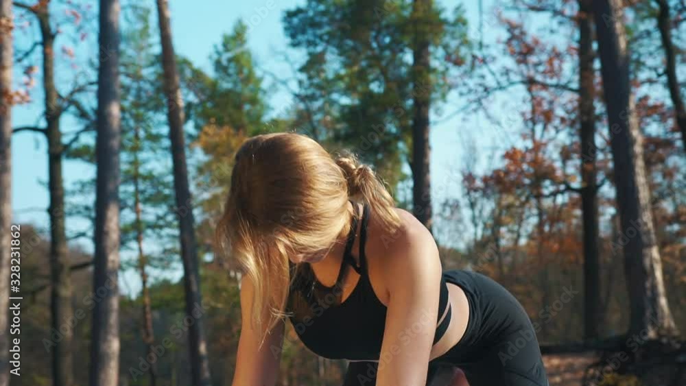 pretty blonde girl in black top practices yoga on mat in beautiful sunny autumn forest closeup slow motion pretty blonde girl in black top practices yoga on mat in beautiful sunny autumn forest closeup slow motion